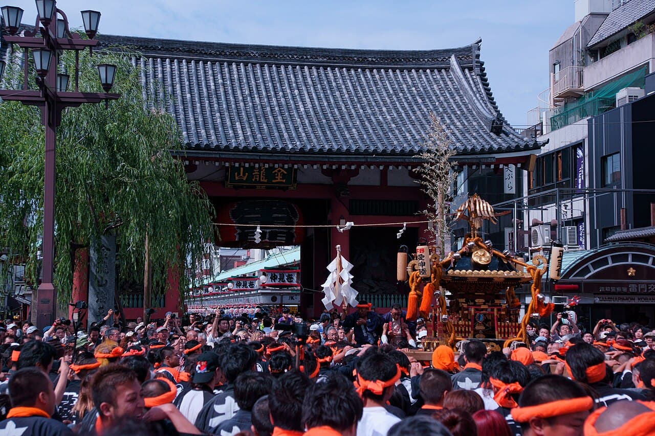 A mikoshi portable shrine being carried through a crowd near Kaminarimon, Asakusa