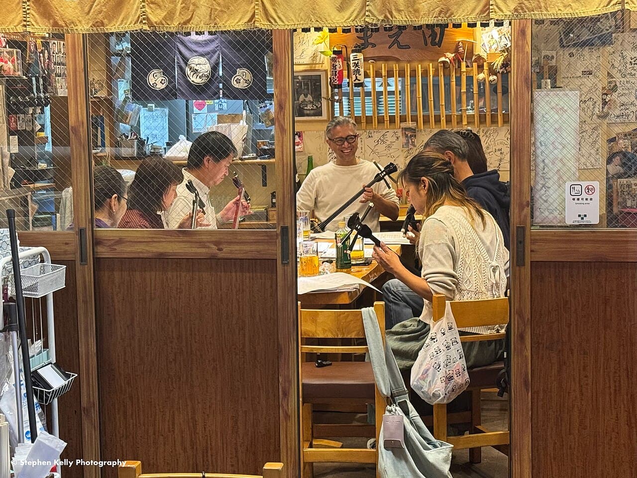 A shamisen trial lesson in Tokyo, showing the traditional three-stringed instrument being played and taught (photographed in Asakusa, Tokyo — closest verified real match; no Shinjuku-specific photo exists on Commons)