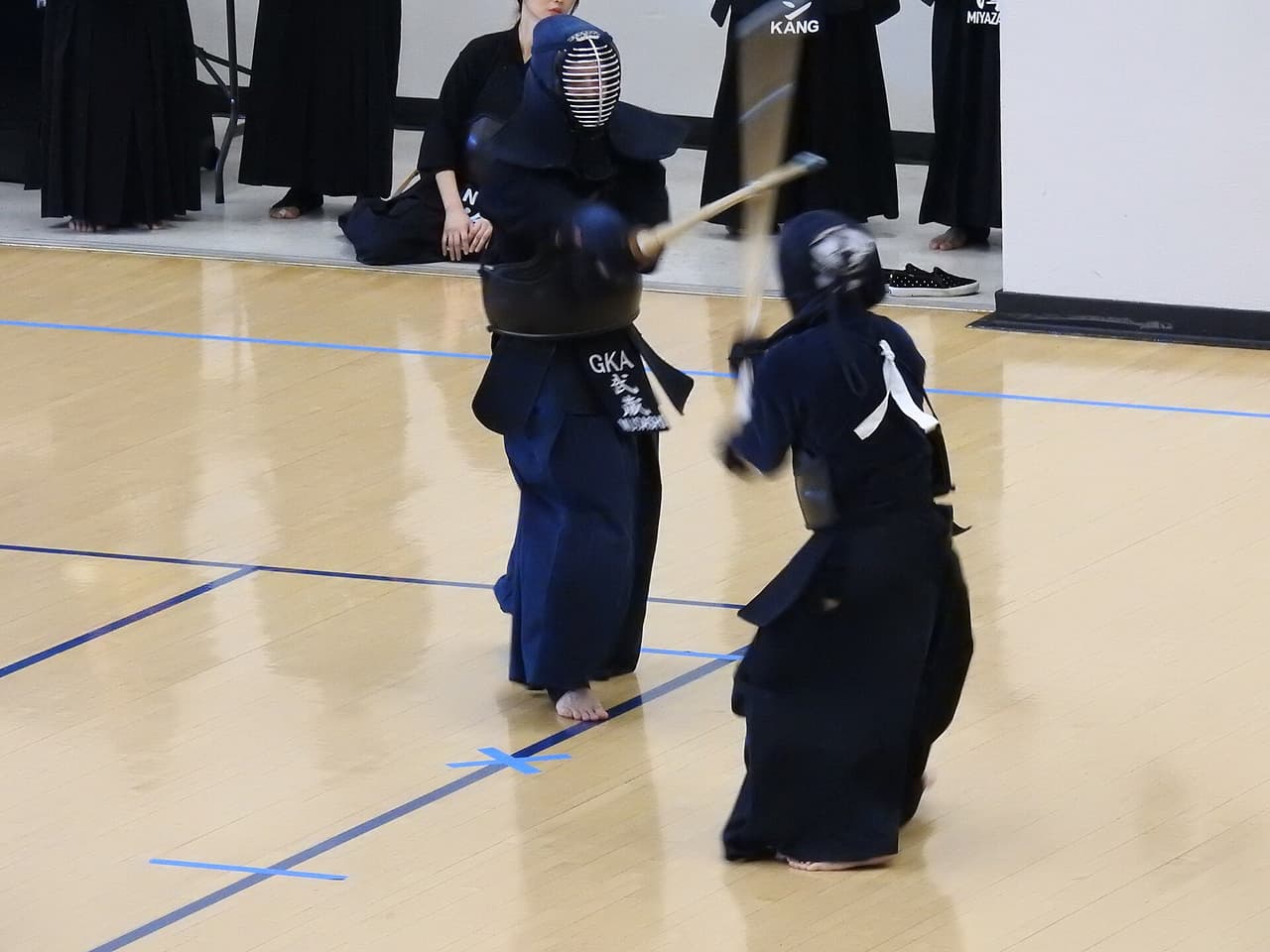 防具を着けた剣道の二人。一方が面を打ち込む瞬間
