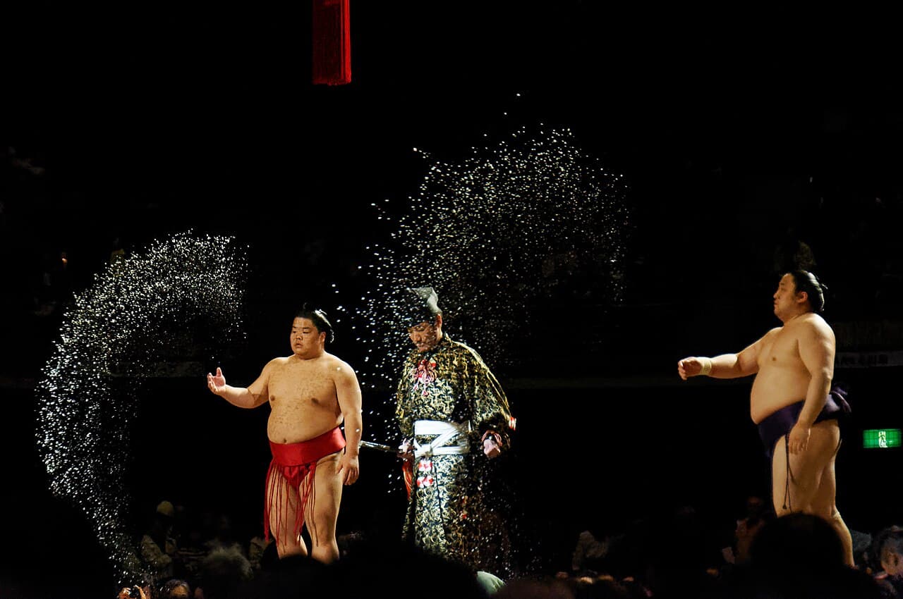 Sumo wrestlers throwing salt into the ring before a bout