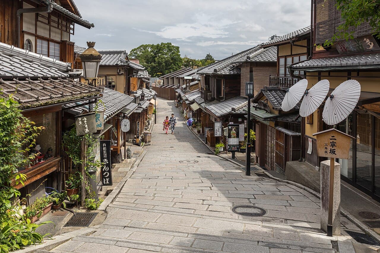 京都・東山の和傘が並ぶ通りを浴衣で歩く人々
