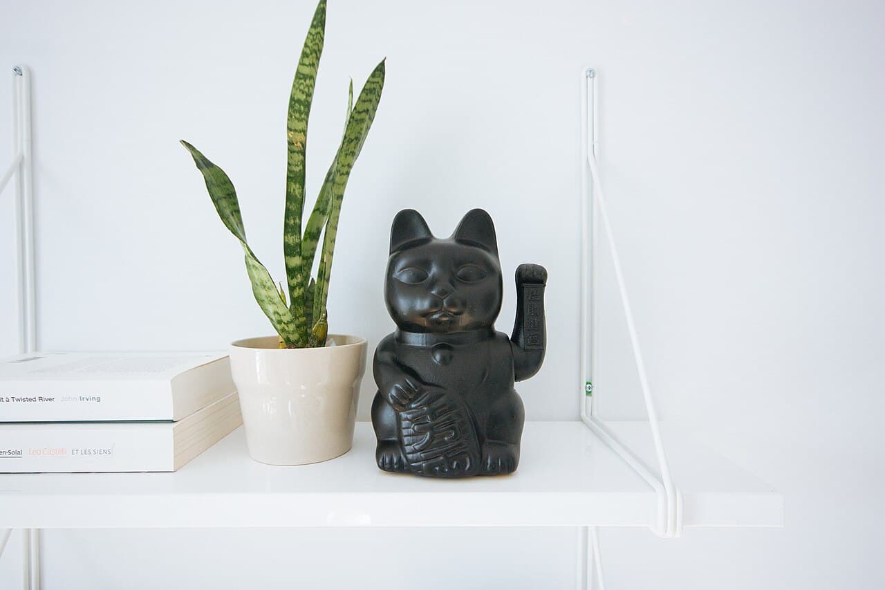 幸運とお金を招くと信じられている、招き猫の陶器の置物