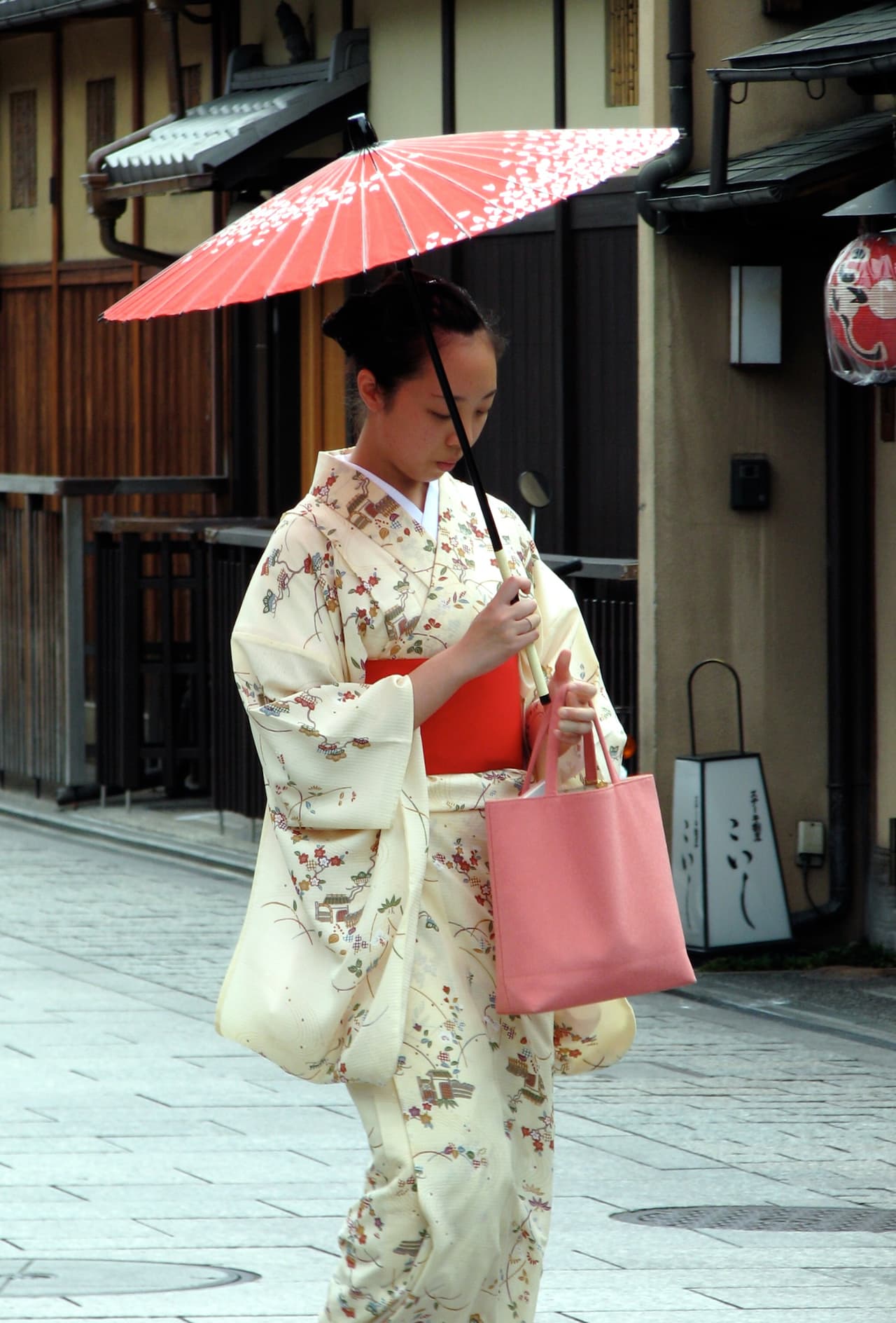 京都・祇園の古い通りを着物で歩く女性
