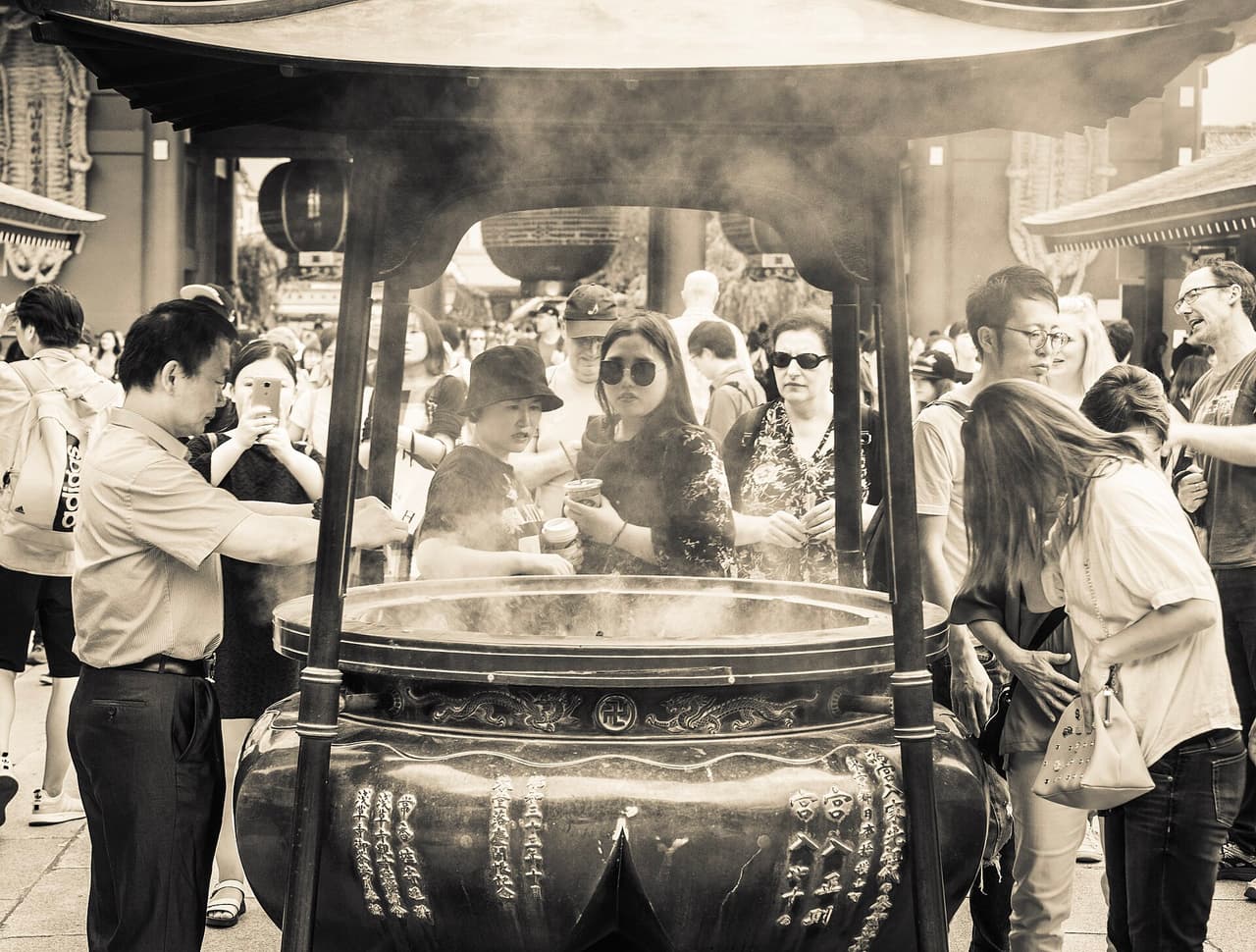 Visitors gathered around the large incense burner (jokoro) in front of the main hall at Senso-ji temple, Tokyo