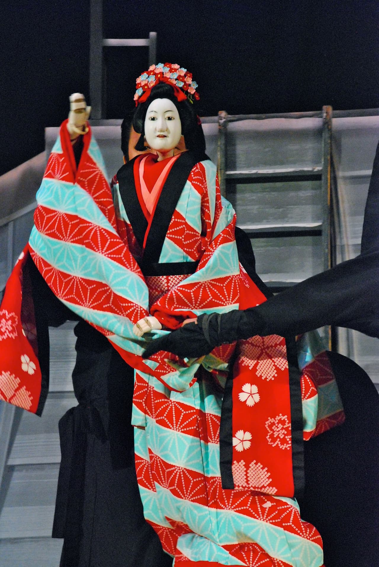 Bunraku puppets worked on stage by visible puppeteers